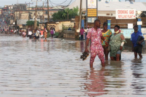 7月，在尼日利亚拉各斯被洪水淹没的Aboru社区，居民们艰难地走过一条路。