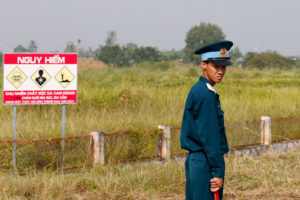 越南士兵旁边的危险警告标志在去年10月的Bien Hoa空中基地的Dioxin污染迹象。