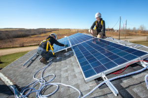 在阿尔伯塔省韦塔斯基温附近的一个托儿中心，前沥青砂工人正在安装太阳能电池板。