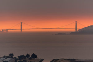 野火的烟雾在旧金山的金门大桥后面产生了橙色的阴霾。