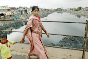 一个妇女和她的儿子在孟买的岩石河越过岩石河。