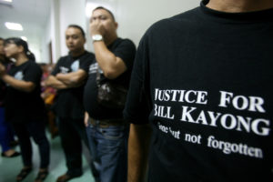 比尔·凯（Bill Kayong）的支持者在法院外面对三名被指控谋杀的男子的审判审判。 
