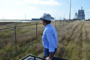 杰森削皮器看着窗外圣米格尔从他的农场Christine燃煤发电厂,德克萨斯州。