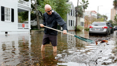南卡罗来纳州的夏尔斯顿居民在2015年10月的潮汐洪水中消除了排水的碎片。这座城市现在经历了50天的“阳光灿烂的日子”洪水洪水一年。