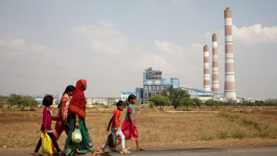 妇女和孩子们在印度Chhattisgarh的一个燃煤电厂走过。