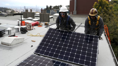工人们在旧金山的一户人家安装太阳能电池板，该市限制了新建筑中使用天然气。