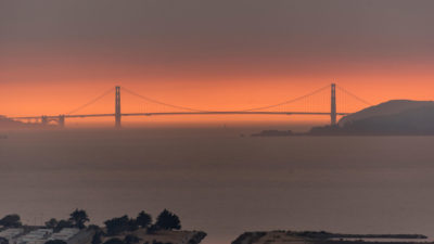 大火产生的烟雾在旧金山金门大桥后面形成了橙色的烟雾。