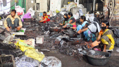 在印度巴特那，工人们正在拆卸汽车电池，为铅回收做准备。