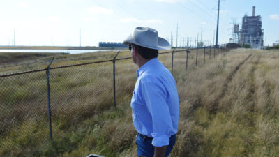 Jason Peeler从德克萨斯州克里斯汀的牧场看着圣米格尔燃煤发电厂。