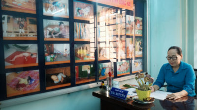 越南特工橙/二恶英受害者协会的Nguyen Dao坐在Bien HOA中有1,000多人与二恶英相关的残疾人中的一些照片中坐下。