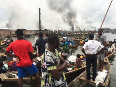 2017年，尼日利亚拉各斯的Otodo game定居点被驱逐的居民看着被当局烧毁的房屋冒烟。