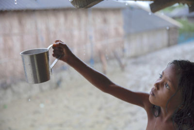 一个女孩收集雨水,Shyamnagar饮用水的主要来源,孟加拉国,水是高盐水。