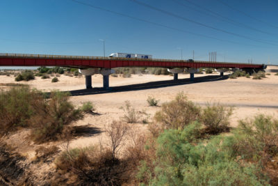 在墨西哥Baja California的圣路易斯里奥罗拉多镇附近，一条高速公路通过科罗拉多河的干旱​​，历史悠久的河床。