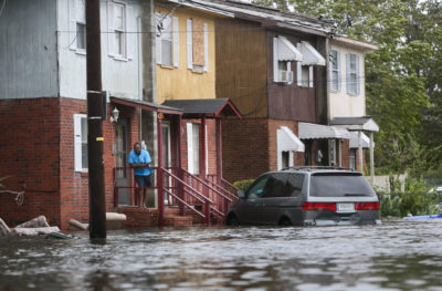 2016年10月，飓风马修造成南卡罗来纳州查尔斯顿的洪水，一名男子站在自家门廊上。