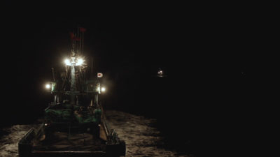 一艘中国鱿鱼船在夜间捕鱼时悬挂着韩国国旗。