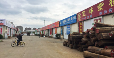 在上海富仁市场，一排批发商店外堆满了红木。