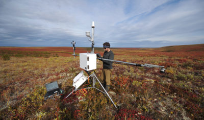 威尔弗里德·劳里埃大学的研究人员布兰登·沃克从西北地区冻土带上的气象站收集数据。