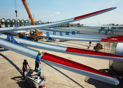中国江苏省连云港，工人们在检查一家工厂的风力涡轮机叶片。