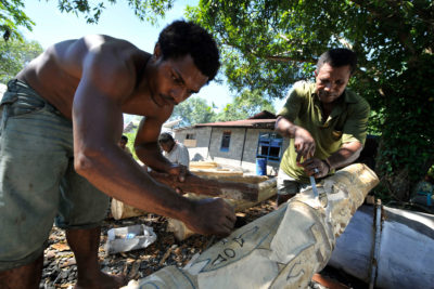 Papuan Temesmen雕刻了传统的木杆。Trans-Papua公路将削减许多土着部落的土地。