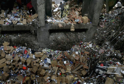 一名工人将垃圾扔进深圳的溢出的废物设施。这座城市今天生产的垃圾比20世纪70年代更多。