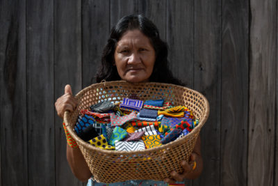 Pukany Village负责人BekwyitexoKayapó拥有一篮子串珠手镯，她和其他Kayapó妇女制作和出售。