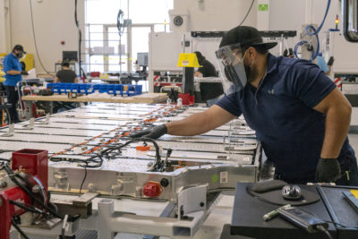 电动车电池面板上一个工人检查连接在纽瓦克的清醒汽车的总部,加利福尼亚。