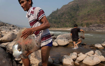 老挝湄公河上的渔民。生态学家正试图确定哪些鱼类在维持河流生态系统中起着关键作用。