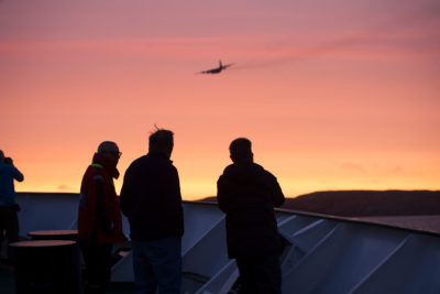 Akademik Ioffe上的乘客看着一架来自安大略省加拿大国防联合救援协调中心的飞机。飞机花了9个小时才到达搁浅的船只。