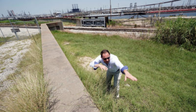 U.Sie的工程师Steve Sherrill工程师队的兵团展示了在2018年7月德克萨斯州港口埃瑟港炼油厂附近的海堤和堤坝中加入了多少高度。
