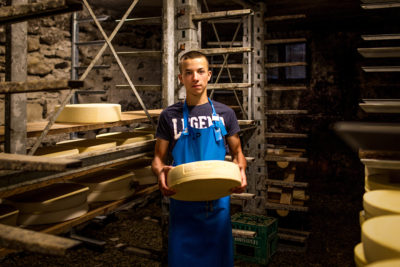 14岁的Filippo Pedranzini在他的家人在福尼山谷的乳制品农场生产的奶酪。