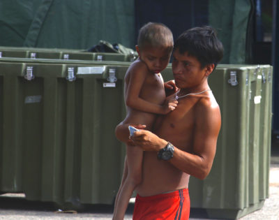 上周，一名Yanomami男子在巴西Roraima的一家陆军野外医院外带一个孩子。